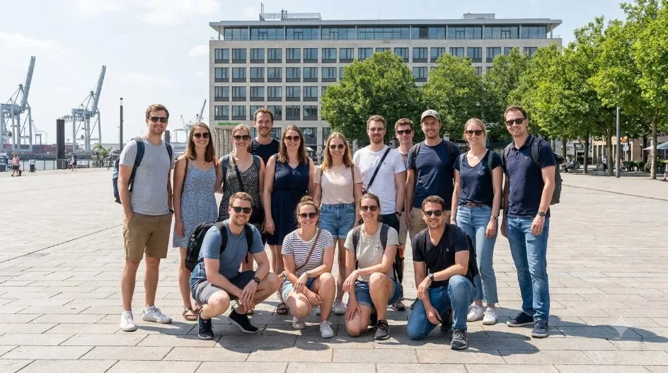 A large group of friends standing together outdoors on a sunny day.