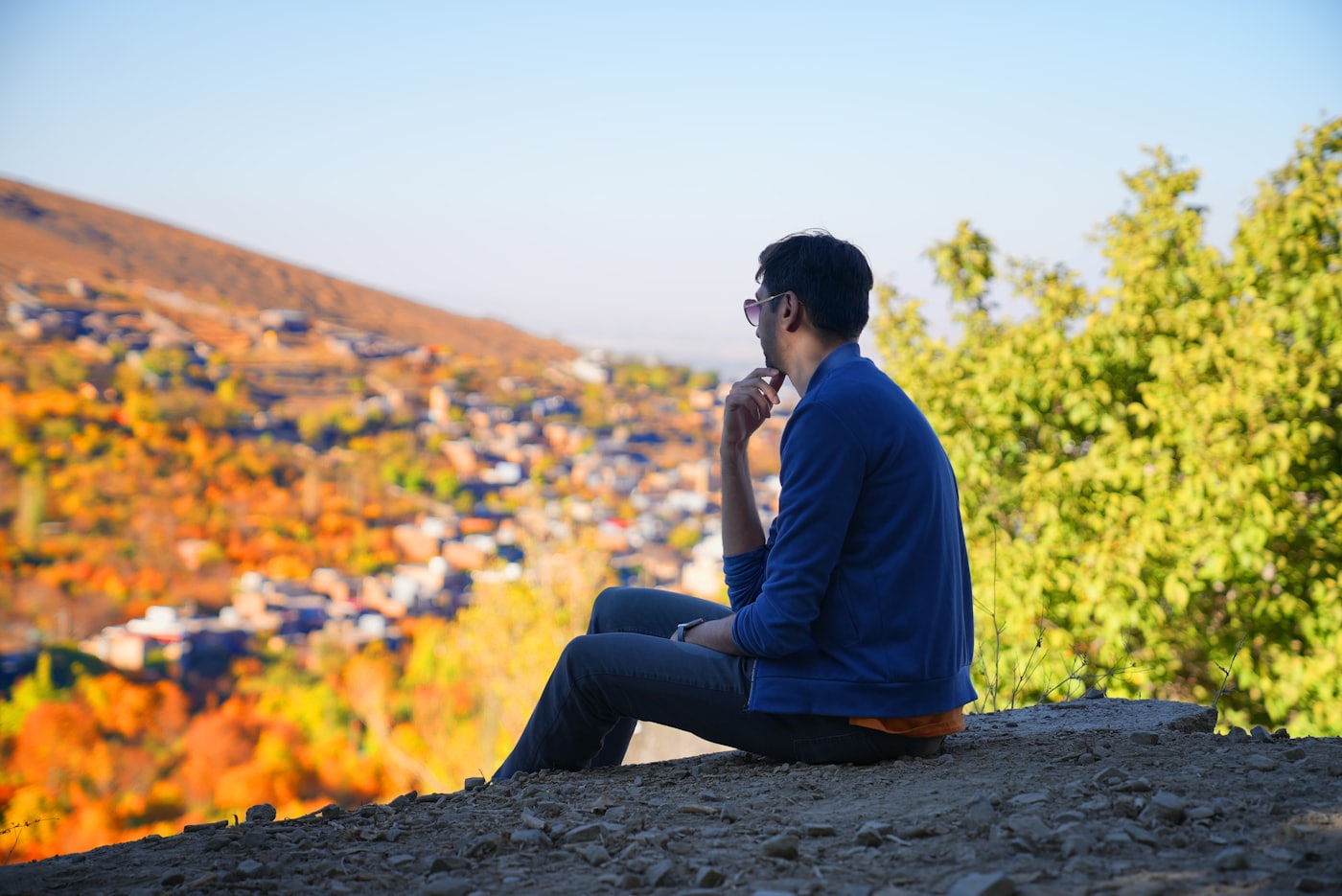 A person sitting outdoors talking on a phone call
